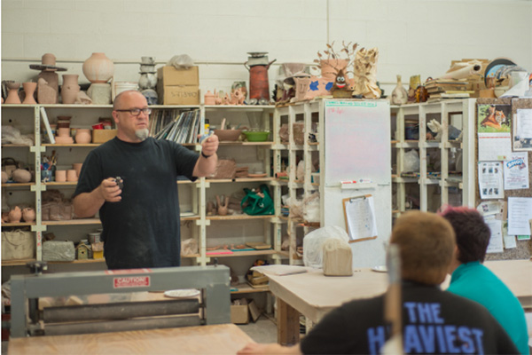 a teacher teaches an art class to illustrate therapeutic impact of music and the arts at black mountain academy for neurodiverse teenage boys